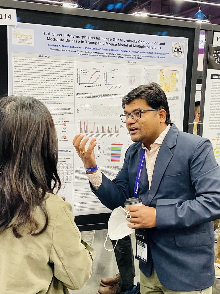 Shailesh talking to another person, pointing at a research poster